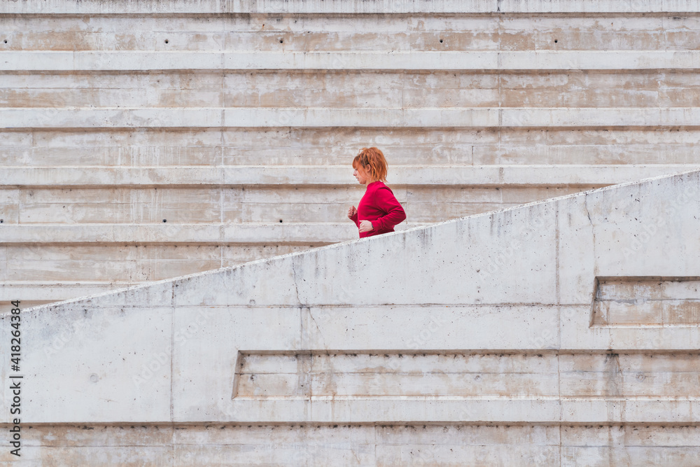 General shot from behind of a woman running down stairs outdoors