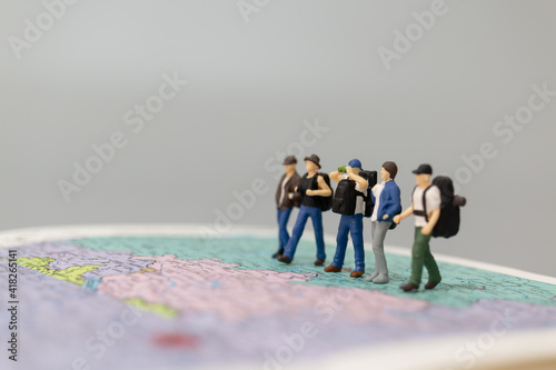 Miniature people Backpacker walking on map Travel and Adventure concepts
