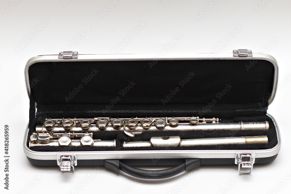Open case with a shiny disassembled flute lying in it Open case with a shiny disassembled flute lying in it