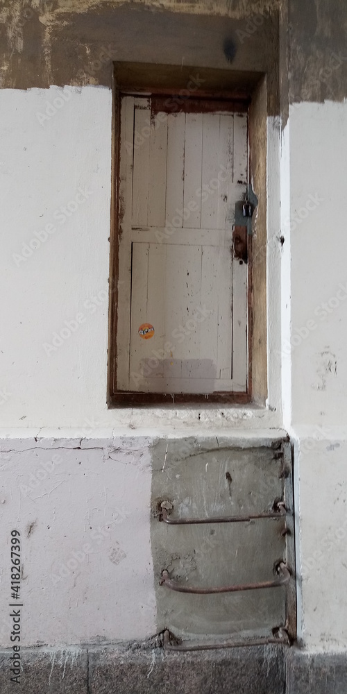 A door in an old wall and a metal staircase to it 