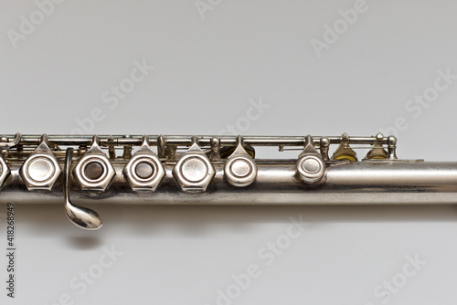 Silvery musical instrument with keys on a white background with soft shadow photo