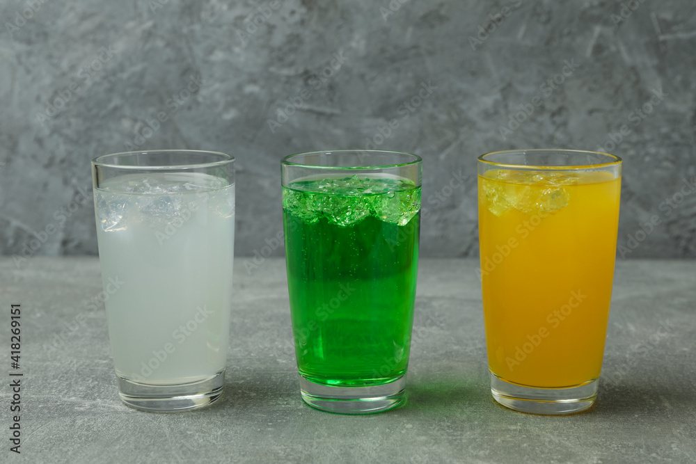 Glasses of different soda on gray background Glasses of different soda on gray background