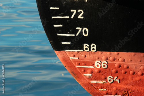 Red ship hull with waterline and draft scale measure