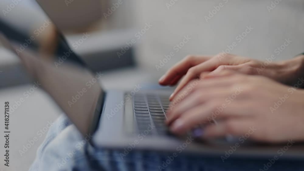 Close up of female hands typing on keyboard of wireless laptop. Young woman sitting on couch and using modern computer. Technology concept. Close up of female hands typing on keyboard of wireless laptop. Young woman sitting on couch and using modern computer. Technology concept.