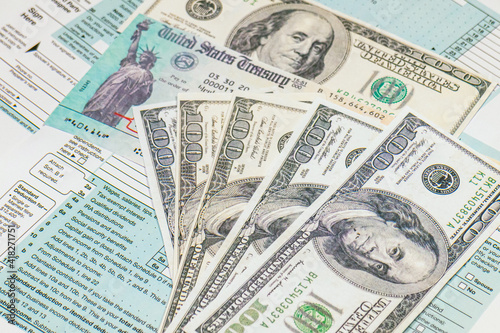 Stimulus economic tax return check and and 1040 Form with dollars.