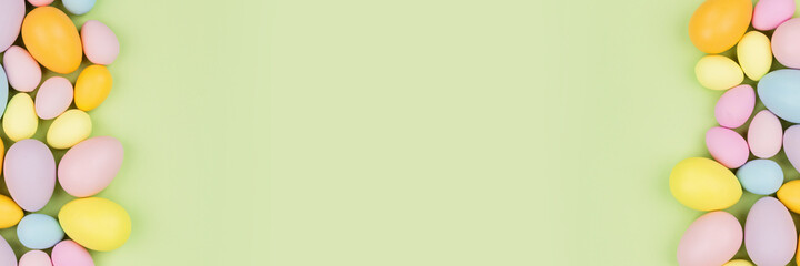 Stylish background with colorful easter eggs pastel colors isolated on green background. Horizontal long banner for web design. Flat lay, top view, mockup, overhead, template