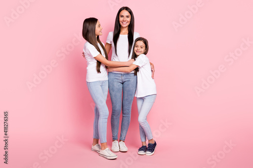 Full length body size photo of two daughters friendly spending time loving mom happy isolated pastel pink color background