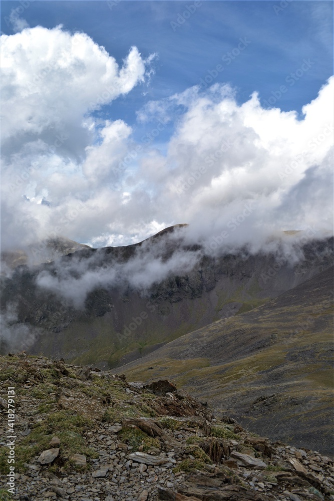 Fototapeta premium Perenei in the clouds. Mountains, clouds, sun, grass