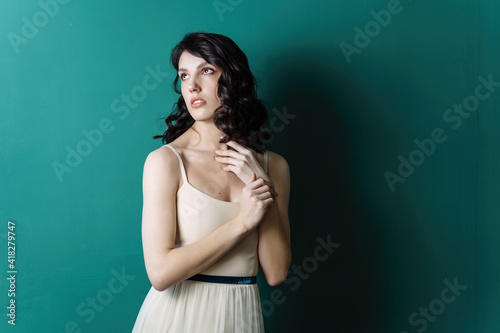 Elegant lady portrait.Pearls jewelry set posing isolated on studio green background. Sensual look up © Alex Li
