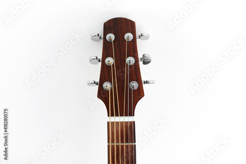music and musical instruments concept - close up of acoustic guitar head with pegs on white background