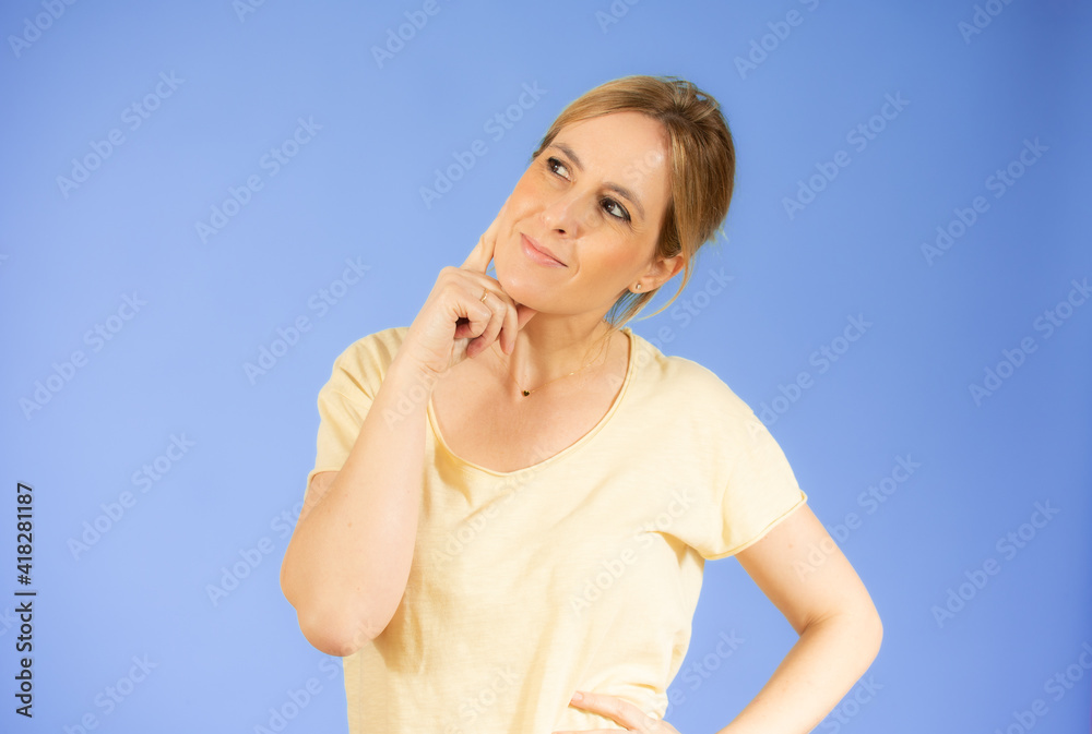 Portrait of a pensive casual woman looking away at copy space isolated over purple background Portrait of a pensive casual woman looking away at copy space isolated over purple background