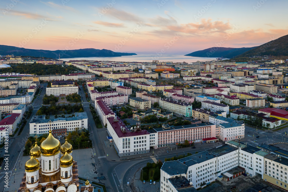 Beautiful morning city landscape. Top view of the Cathedral, streets and buildings. Aerial view of the city of Magadan. Nagaev Bay in the distance. Magadan, Magadan region, Far East Russia, Siberia.