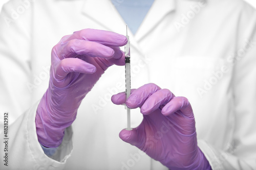 medicine, vaccination and healthcare concept - close up of female doctor or nurse with syringe over white background