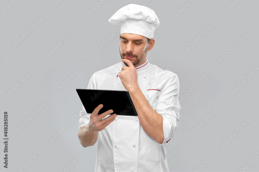 cooking, culinary and people concept - male chef in toque with tablet pc computer over grey background cooking, culinary and people concept - male chef in toque with tablet pc computer over grey background