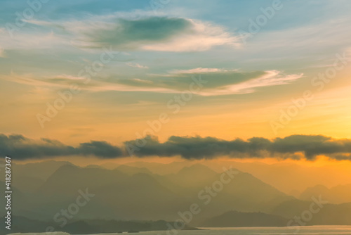 Beautiful scenery with clouds during sunrise with mountain view as background.
