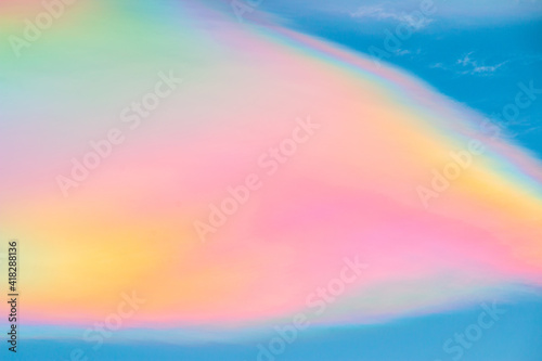 Multicolored rainbow cloud in natural sky background. Unusual and beautiful meteorological atmospheric phenomenon called irisation or iridescent. Circumhorizontal arc or rainbow of fire cirrus clouds.