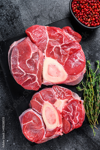 Raw beef meat osso buco shank steak, italian ossobuco. Black background. Top view