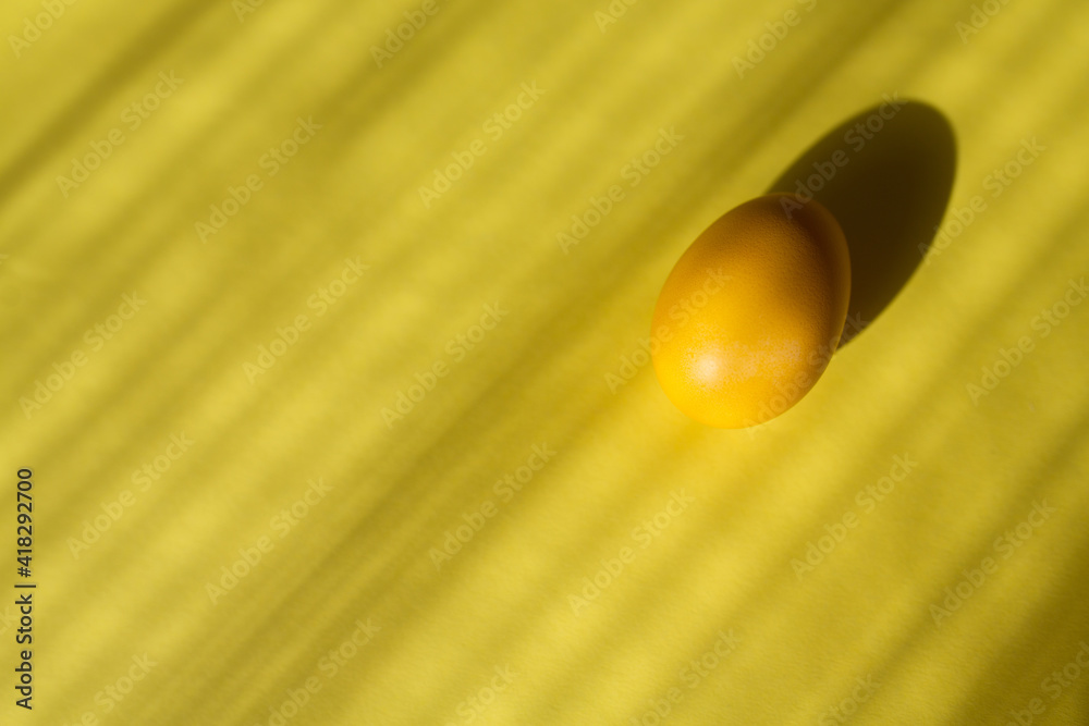 Yellow Easter egg against a yellow background with copy space. Happy easter 2021. Yellow Easter egg against a yellow background with copy space. Happy easter 2021.
