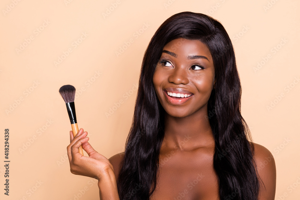 Photo of dreamy girlish brunette charming lady hold cosmetic brush look up empty space isolated beige background Photo of dreamy girlish brunette charming lady hold cosmetic brush look up empty space isolated beige background