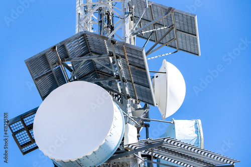 Telecommunication tower with television (TV), satellite and 5G antennas with blue sky. Arrival of 5G mobile telephony and problems of electromagnetic radiation and cancer of electromagnetic waves.