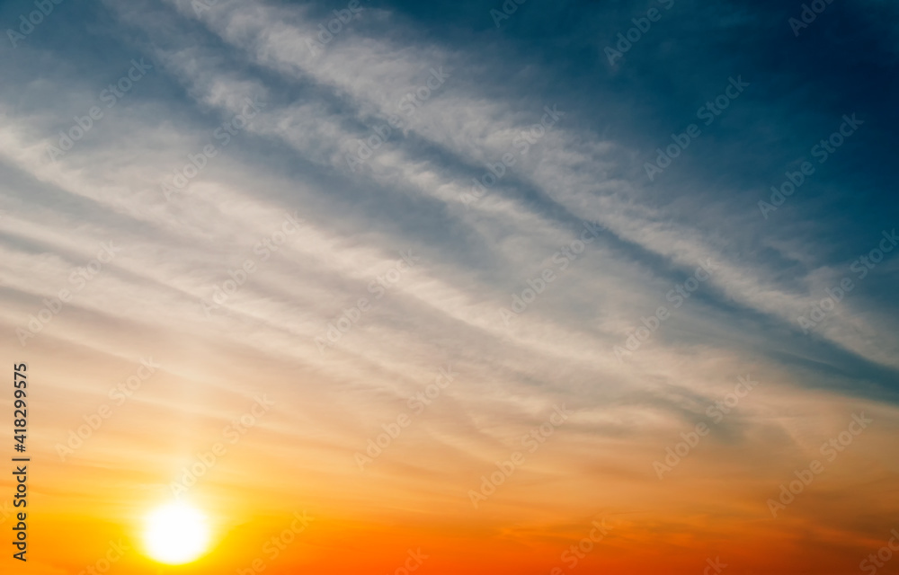Fototapeta premium Stunning sunset with orange and blue clouds in dramatic sky