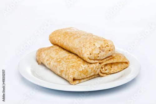 Rolled stuffed pancake on white plate 