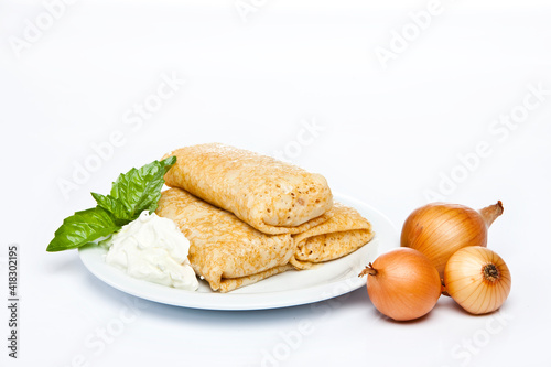Rolled stuffed pancake on white plate 