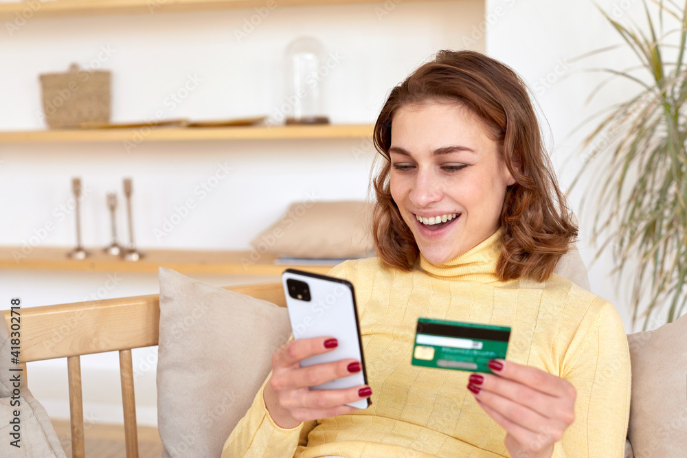 Happy millennial Caucasian woman hold modern smartphone and plastic credit card shopping online, smiling young woman make internet payment or purchase using web banking system on cellphone gadget Happy millennial Caucasian woman hold modern smartphone and plastic credit card shopping online, smiling young woman make internet payment or purchase using web banking system on cellphone gadget
