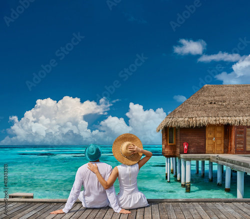 Couple in white on a tropical beach jetty