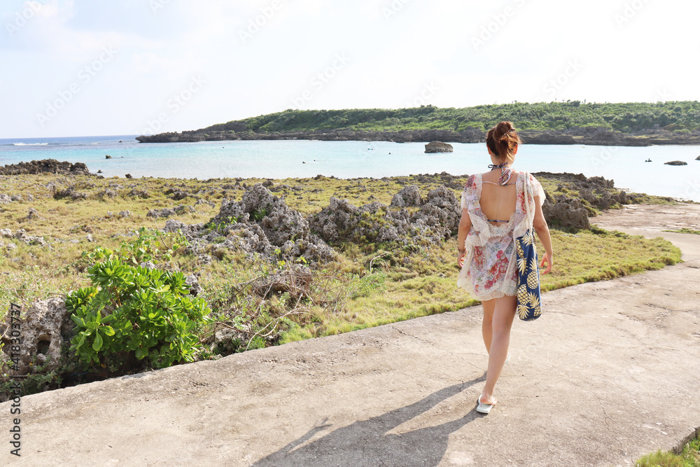 リゾートで海岸を歩く女性