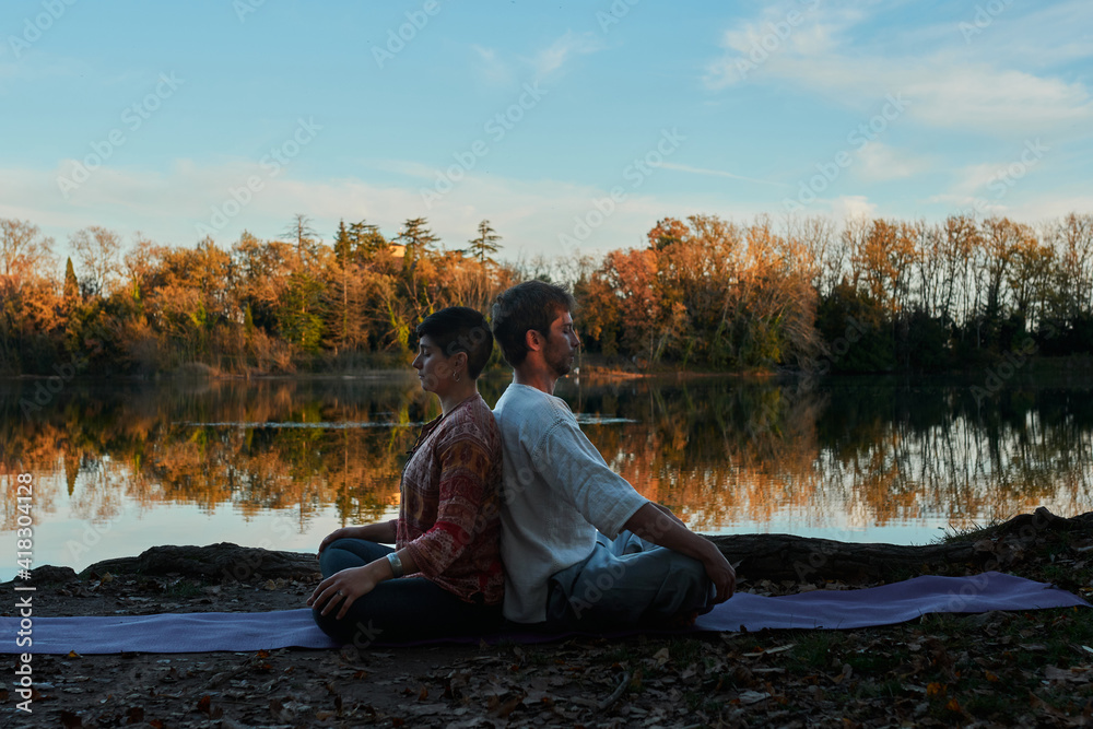 couple doing yoga by the lake