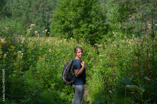 a girl in a sports style stands on a beautiful green meadow © Надежда Долгова