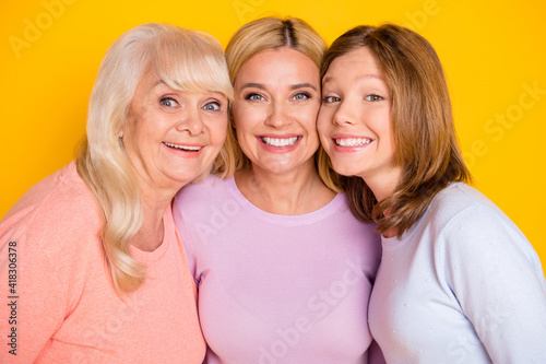 Photo of nice optimistic three woman grand mom daughter wear pastel cloth isolated on yellow color background