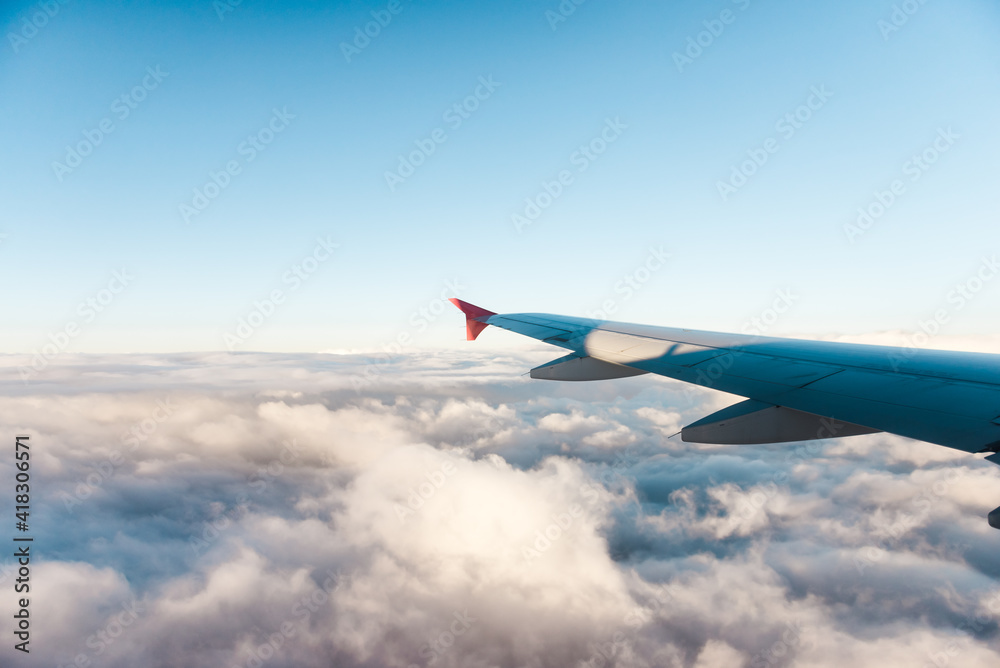 Fototapeta premium Wing of a plane flying over the clouds