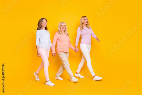 Full size profile photo of optimistic three woman grand mom daughter go wear pastel cloth isolated on yellow background