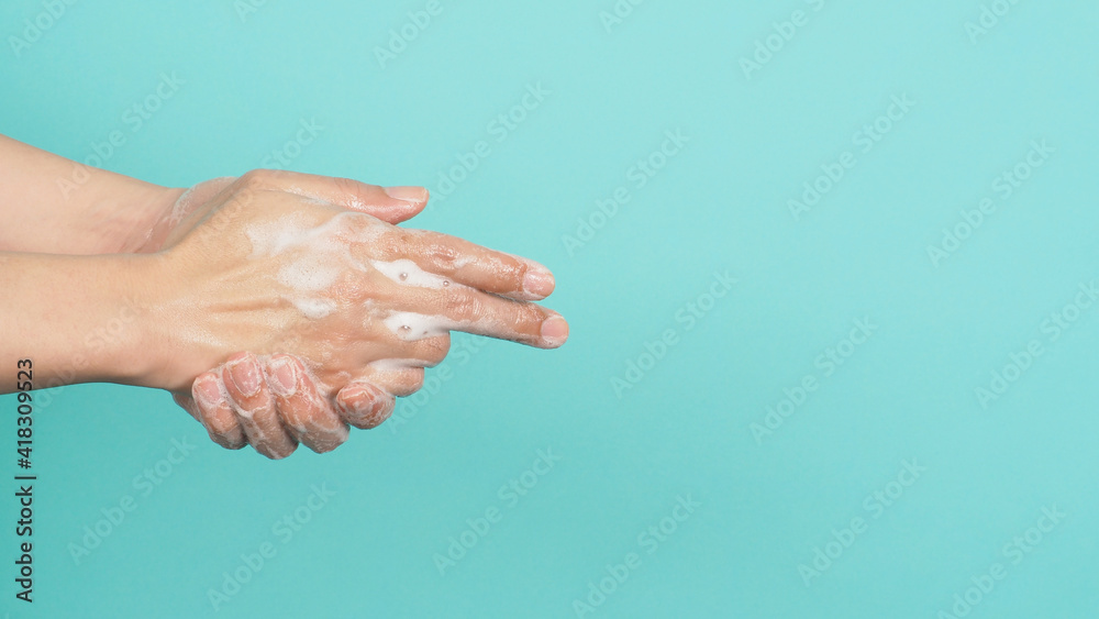 Fototapeta premium Hands washing gesture with foaming hand soap on green and Tiffany Blue background.