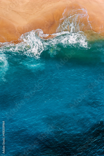 Beautiful sandy beach with blue sea  vertical view. Drone view of tropical blue ocean beach Nusa penida Bali Indonesia. Lonely sandy beach with beautiful waves. Beaches of Indonesia. Copy space
