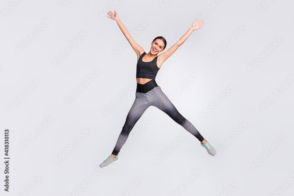 Full length photo of charming cheerful young woman jump up star shape sportive isolated on grey color background