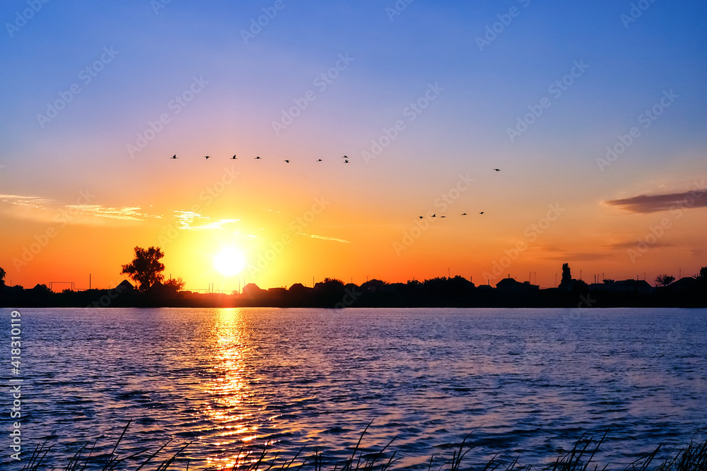 Birds over the river at sunrise