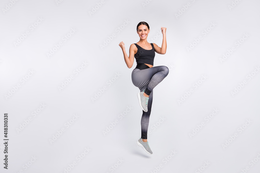 Full length photo of attractive nice young woman active energetic athlete isolated on grey color background