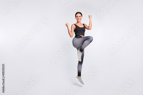 Full length photo of attractive nice young woman active energetic athlete isolated on grey color background