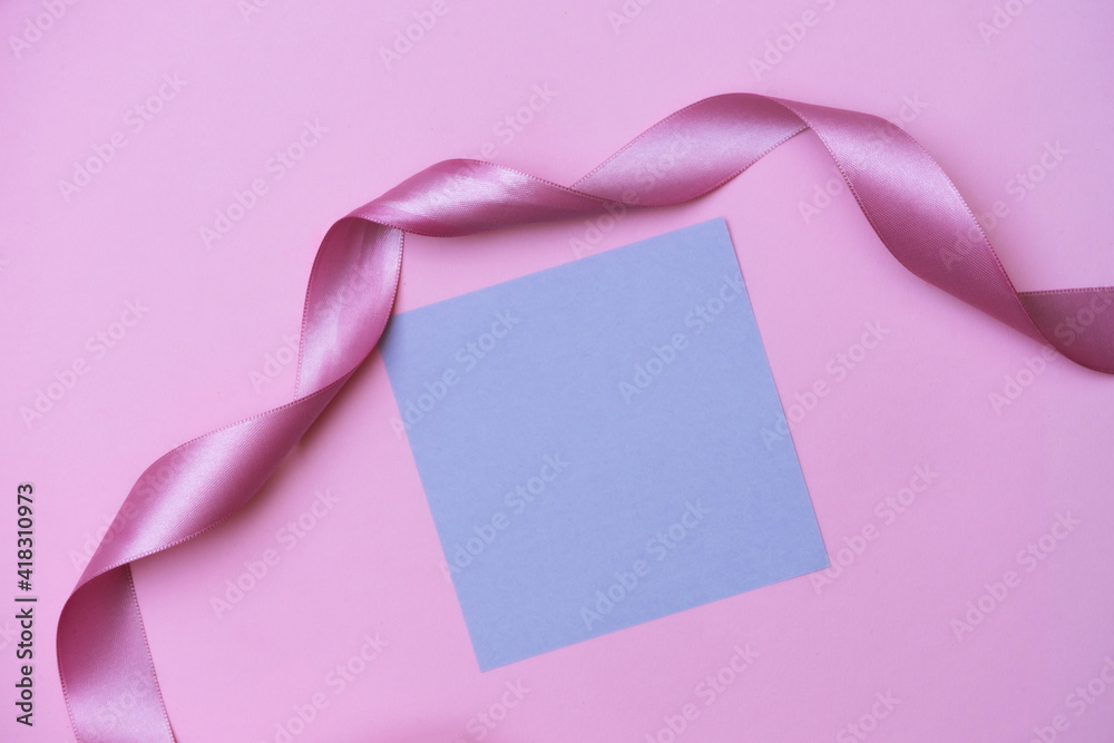Pink ribbon and purple sticker on the pink background. Copyspace background.