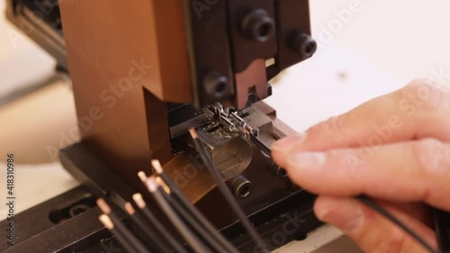 Hand apply wire connector terminals to electric wires using a crimping machine - close up, static camera photo