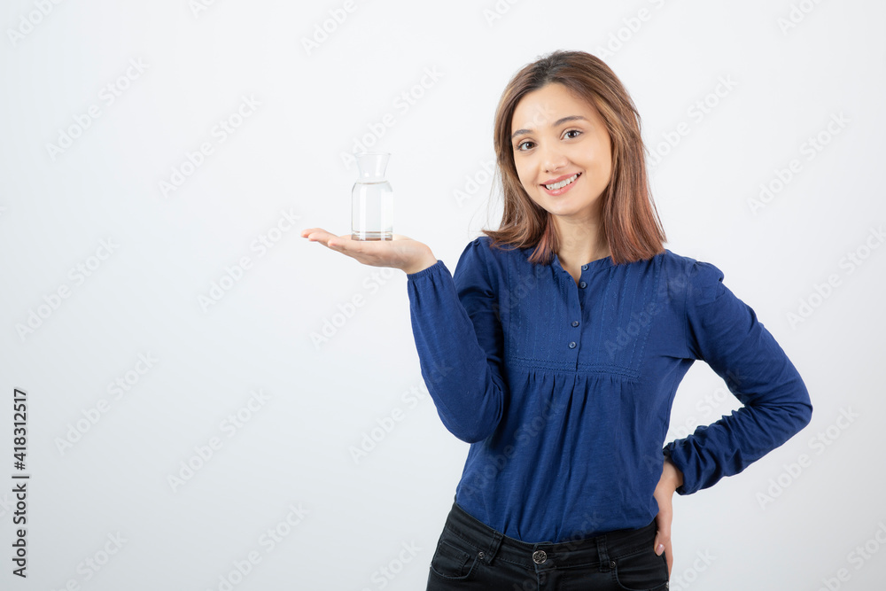 Portrait of young adorable girl holding glass of water on white background Portrait of young adorable girl holding glass of water on white background