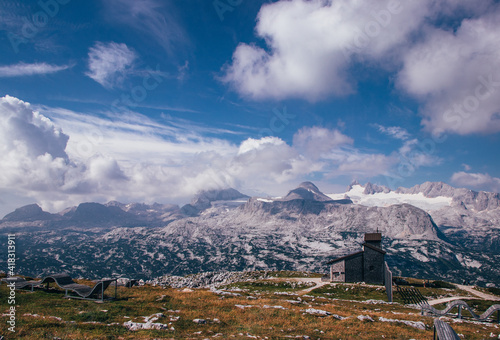 panorama of the Dachstein massif in the schladming area of upper Austria close to the hallstattsee. A wooden hut to protect the sheep from the storm. Hoher Dachstein with a year-round glacier