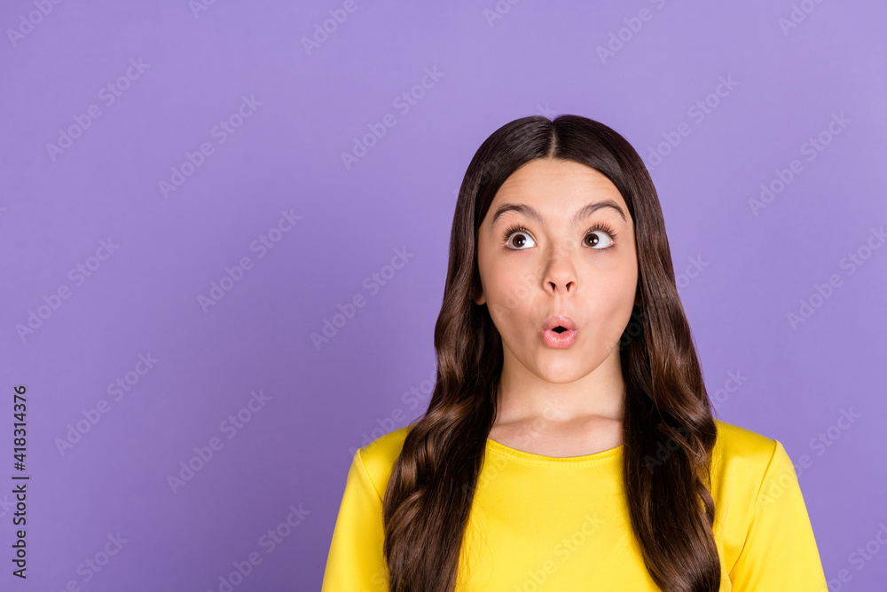 Portrait of nice impressed brunette hairdo girl look empty space wear yellow t-shirt isolated on vivid lilac color background Portrait of nice impressed brunette hairdo girl look empty space wear yellow t-shirt isolated on vivid lilac color background