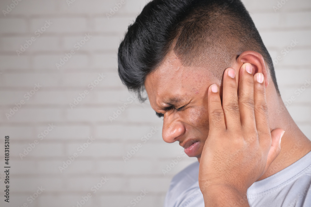 Fototapeta premium side view of young man suffering pain in ear 