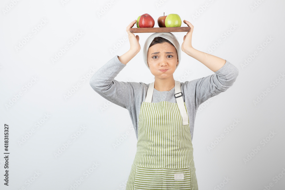 Portrait of adorable female cook holding plate of apples on white background Portrait of adorable female cook holding plate of apples on white background