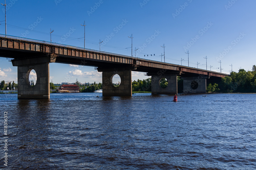 Bridge on a river against a blue sky and clouds Bridge on a river against a blue sky and clouds