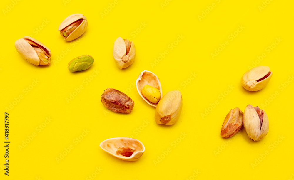Close-up of fresh pistachio nuts on a yellow background. Close-up of fresh pistachio nuts on a yellow background.